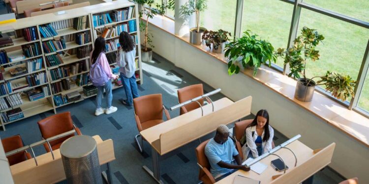Em ГѓВўngulo aberto, vemos alunos estudando em uma biblioteca ampla pensando na escolha do Sisu 2023