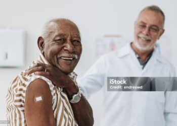 Senior man bandaging vaccine on arm