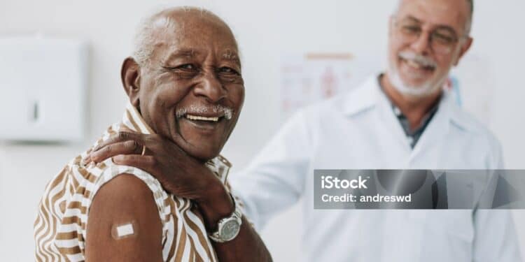 Senior man bandaging vaccine on arm