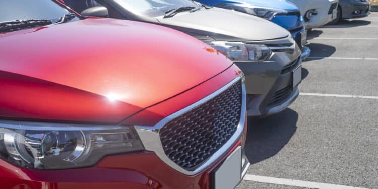 Car parking in asphalt parking lot in a row, front of  cars close up, automobile transportation dealer business concept