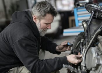 Homem barbudo consertando motocicleta em oficina | Fonte: Pexels