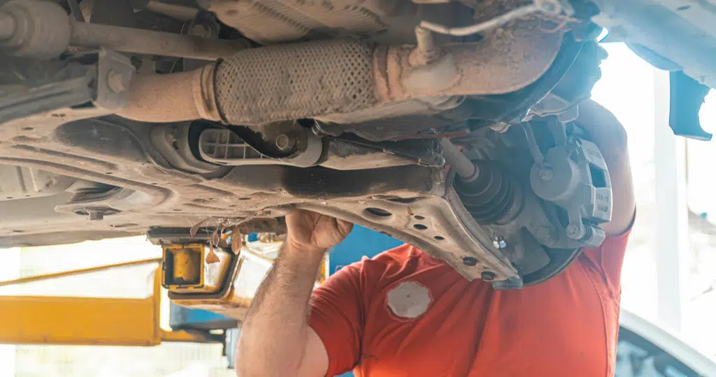 Mecânico checando a suspensão do carro | Fonte: Pexels