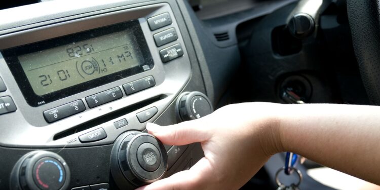 Mulher ajustando volume do rádio do carro | Fonte: PIXNIO | Direitos autorais: Amanda Mills, USCDCP