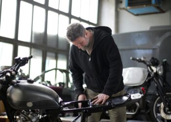 Homem arrumando sua moto | Fonte: Pexels