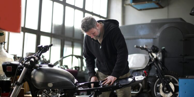 Homem arrumando sua moto | Fonte: Pexels