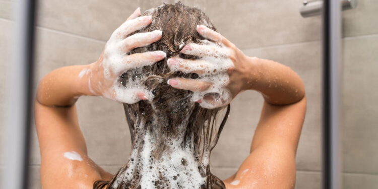 Mulher lavando o cabelo com shampoo - Créditos: depositphotos.com / IgorVetushko