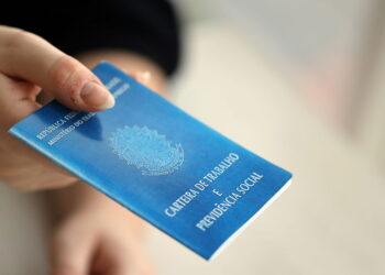 Woman boss gives a brazilian work card and social security blue book to us in employment office close up - Créditos: depositphotos.com / Mehaniq