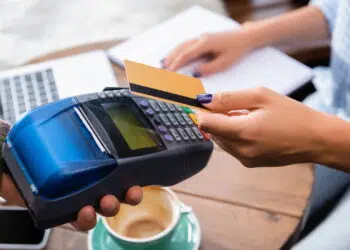 Pessoa passando cartão de crédito em máquina de cartão - Créditos: depositphotos.com / HayDmitriy