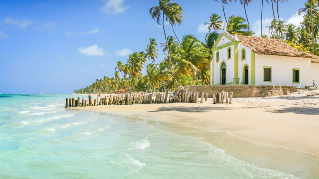 Pouca gente conhece essa praia com mar lindo e igreja à beira-mar