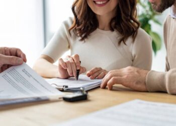 Casal assinando contrato de seguro; proteção financeira.