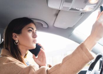 A lei do uso do celular ao volante vai muito além de atender ligações enquanto dirige - Créditos: depositphotos.com / IgorVetushko