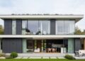 Casa contemporânea de 140 metros quadrados com 3 quartos, fachada de vidro e telhado oculto para famílias jovens