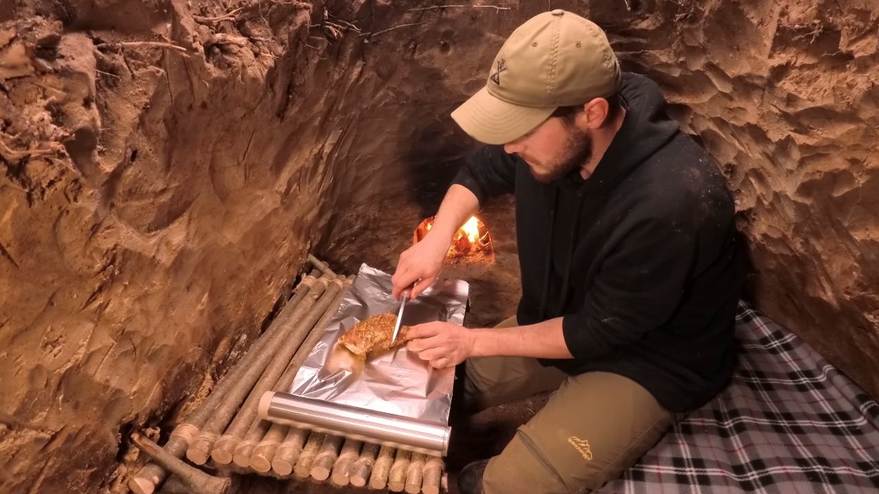 Em silêncio na mata, ele constrói abrigo escondido usando barro, folhas e um tronco caído no chão