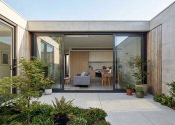 A fachada com brises deixa a casa pequena e moderna mais privada, reduz calor e mantém o visual contemporâneo com luz filtrada