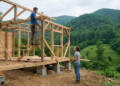Jovem casal constrói sozinho em 349 dias uma casa dos sonhos com dois andares em um campo verde no meio da natureza