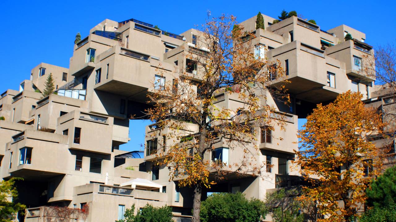 Empilhados como blocos de Tetris que parecem prestes a cair, estes 354 cubos de betão no Canadá mudaram para sempre o conceito de moradia comunitária de luxo