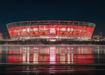 Com sua fachada vermelha e branca de 11 mil painéis de aço, o estádio de 58 mil lugares virou o maior símbolo esportivo e nacional de toda a Polônia