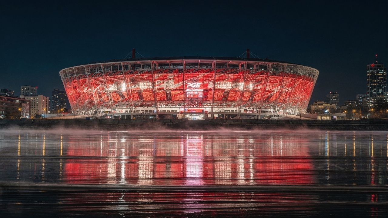 Com sua fachada vermelha e branca de 11 mil painéis de aço, o estádio de 58 mil lugares virou o maior símbolo esportivo e nacional de toda a Polônia