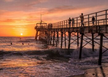 Com sua estrutura metálica de 1923 avançando sobre o mar, a Ponte dos Ingleses virou o maior símbolo do pôr do sol na Praia de Iracema, em Fortaleza