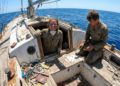 Casal jovem trabalhando na restauração de um iate clássico que agora parece recém saído de fábrica
