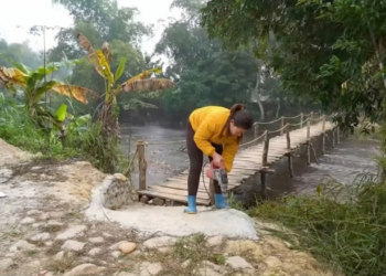 Mulher finaliza construção de ponte de aço com soldagem reforçada após desastre natural
