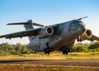 Decolagem épica do KC-390 em ângulo inclinado sob a luz dourada do cerrado.