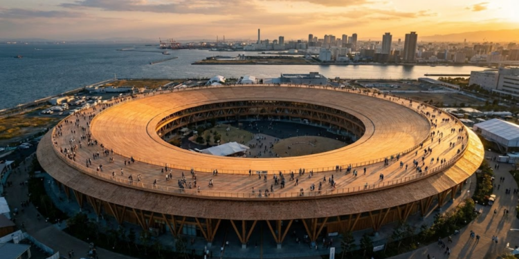 Uma vista aérea impressionante do Great Ring em Osaka durante o pôr do sol, mostrando sua escala gigantesca de madeira abraçando o parque e a baía