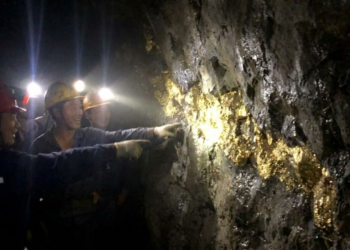 Foto com aspecto vazado de mineiros descobrindo um veio gigante de ouro bruto