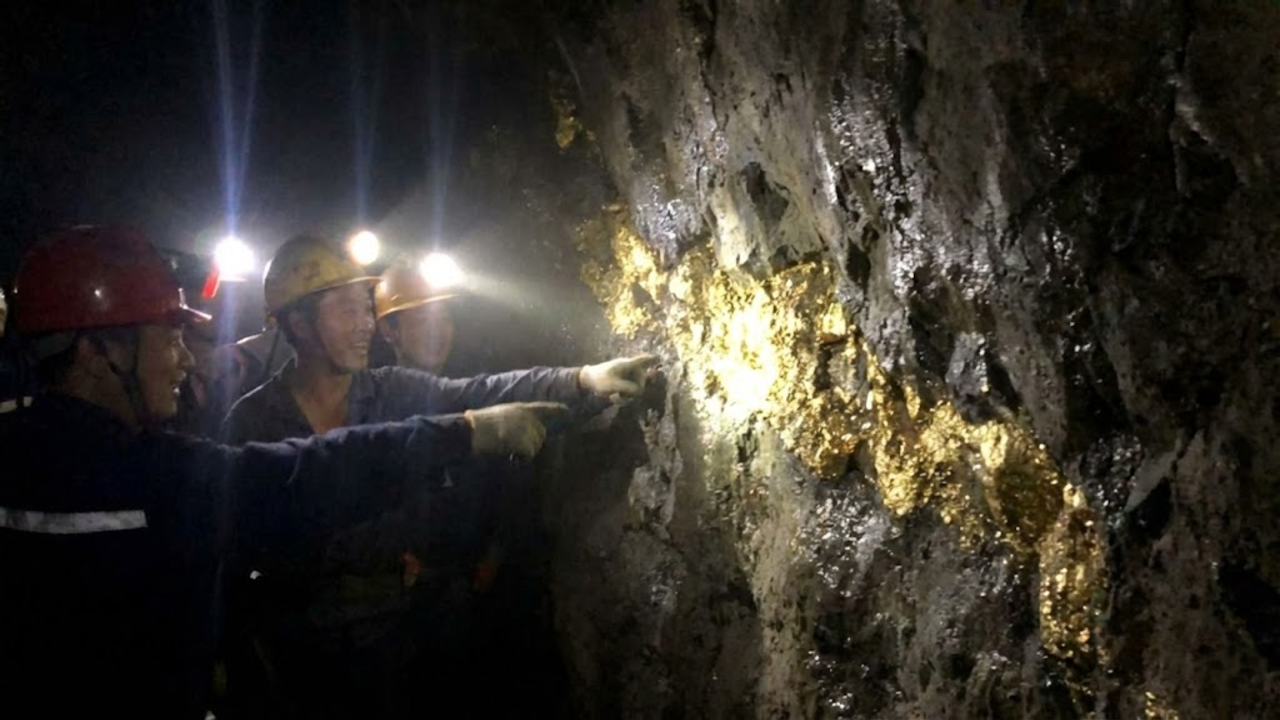 Foto com aspecto vazado de mineiros descobrindo um veio gigante de ouro bruto