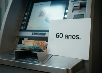 Idoso brasileiro confuso no caixa eletrônico sendo abordado por estranho