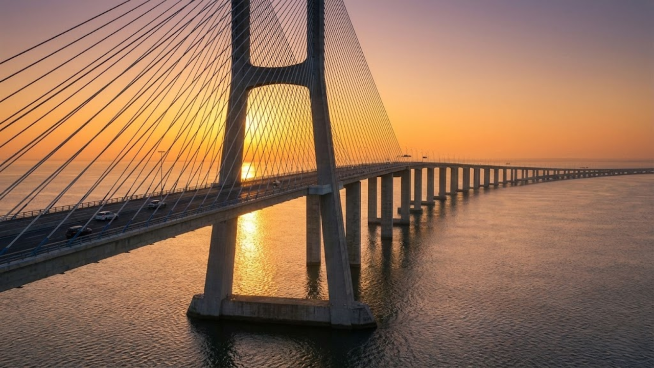 Vista monumental da Ponte Vasco da Gama sobre o rio ao pôr do sol