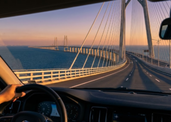 Vista monumental de dentro de um carro da ponte gigante cruzando o mar ao pôr do sol