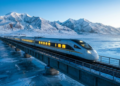 Trem moderno cruzando a paisagem gelada e monumental do Tibet iluminado pelo sol da manhã