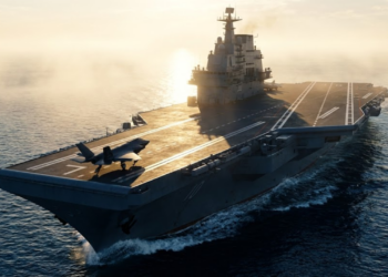 Vista monumental do gigante porta-aviões de pista plana lançando um caça ao nascer do sol.