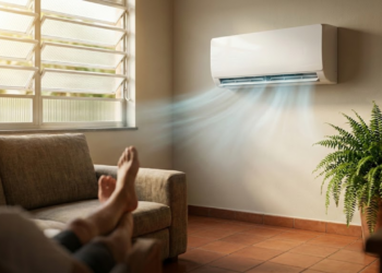 Aparelho de ar moderno e discreto resfriando uma sala brasileira banhada pelo sol.