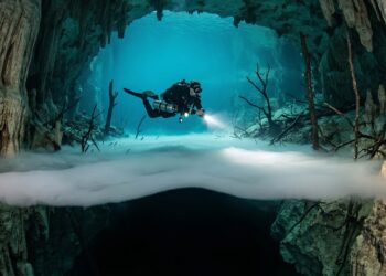 Mergulhadores encontram um rio correndo debaixo d'água e coberto por névoa no fundo de uma caverna no México