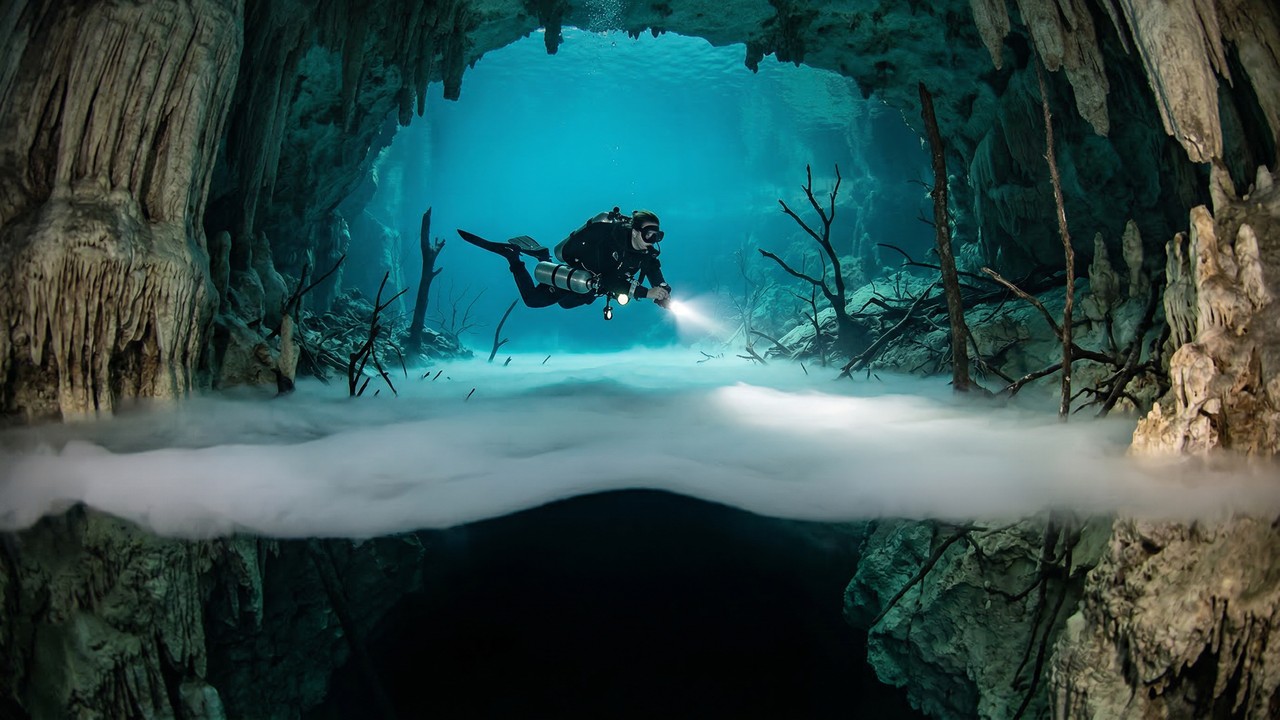 Mergulhadores encontram um rio correndo debaixo d'água e coberto por névoa no fundo de uma caverna no México