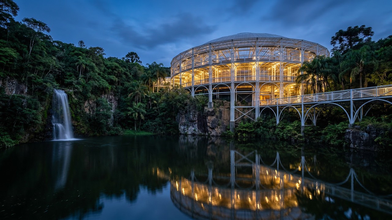 Com estrutura de tubos de aço e teto transparente de 1992, o teatro curitibano virou o maior símbolo da arquitetura integrada à natureza no Paraná