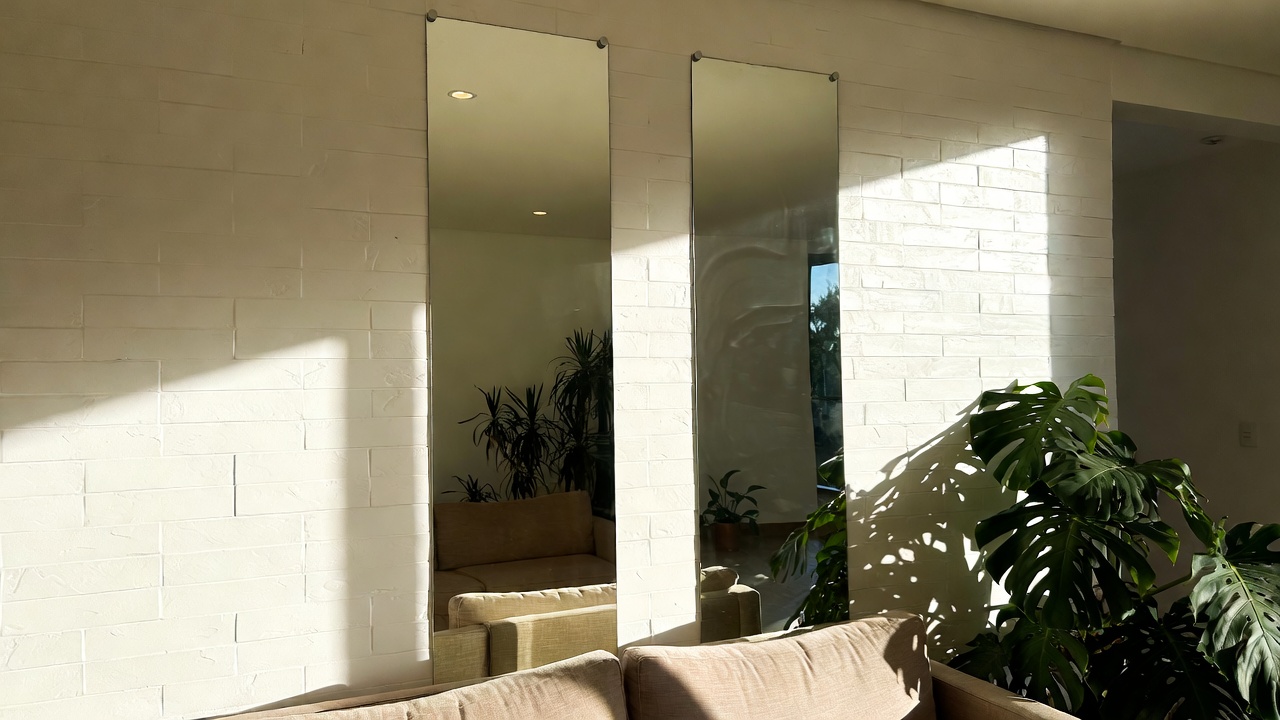 Instalar 2 espelhos verticais na parede oposta à janela aumenta a iluminação natural da sala em até 40 por cento e cria um ambiente visualmente gigante