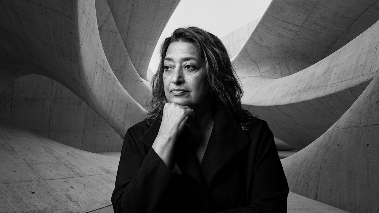 Retrato pensador e intenso de Zaha Hadid em preto e branco.