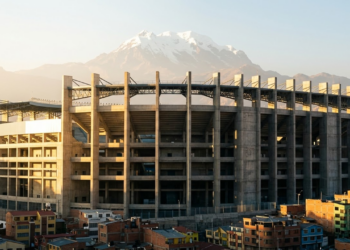 Arena monumental sob a luz dourada com o monte Illimani ao fundo.