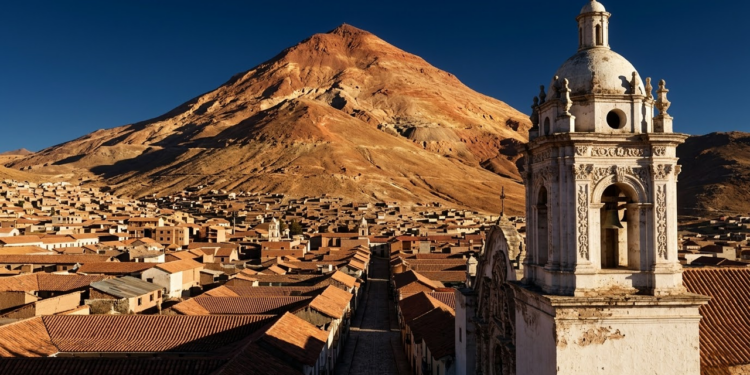 Vista épica do Cerro Rico dominando a cidade colonial de Potosí ao pôr do sol.