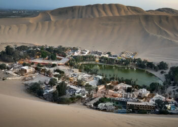 O oásis verdadeiro no meio de dunas de 500 metros de altura que abriga 1 vila isolada em torno de 1 lagoa verde esmeralda