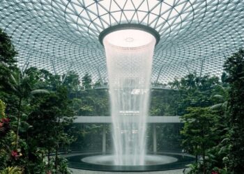 O coração do aeroporto abriga a HSBC Rain Vortex, uma queda d'água monumental com 40 metros de altura, equivalendo perfeitamente a um edifício residencial de 13 andares