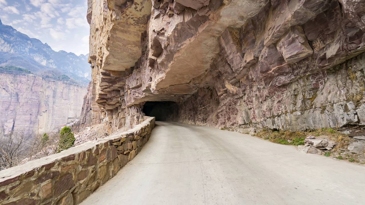 Esculpido à mão em rocha sólida com 30 janelas naturais, o túnel chinês de 1,2 km ganha fama, pois sua obra de 1972 permitiu o acesso à vila