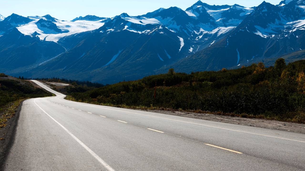 A rodovia de 244 km conecta o interior do Alasca à costa canadense; seu traçado histórico atravessa vales glaciais e picos cobertos de neve