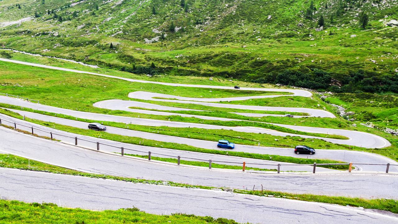 Conectando a Suíça à Itália a 2.113 metros de altitude, esta estrada sinuosa preserva séculos de história em trechos íngremes