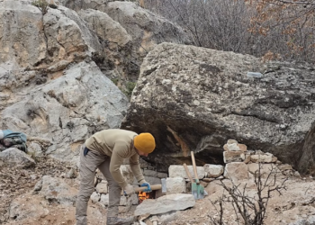 Cabana de pedra primitiva, robusta e confortável, com lareira
