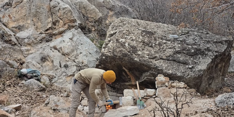 Cabana de pedra primitiva, robusta e confortável, com lareira