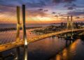 A monumental estrutura estaiada de 1,78 km de extensão com mastros de 103 metros de altura que se eleva sobre o rio Potengi para ligar as praias da zona norte